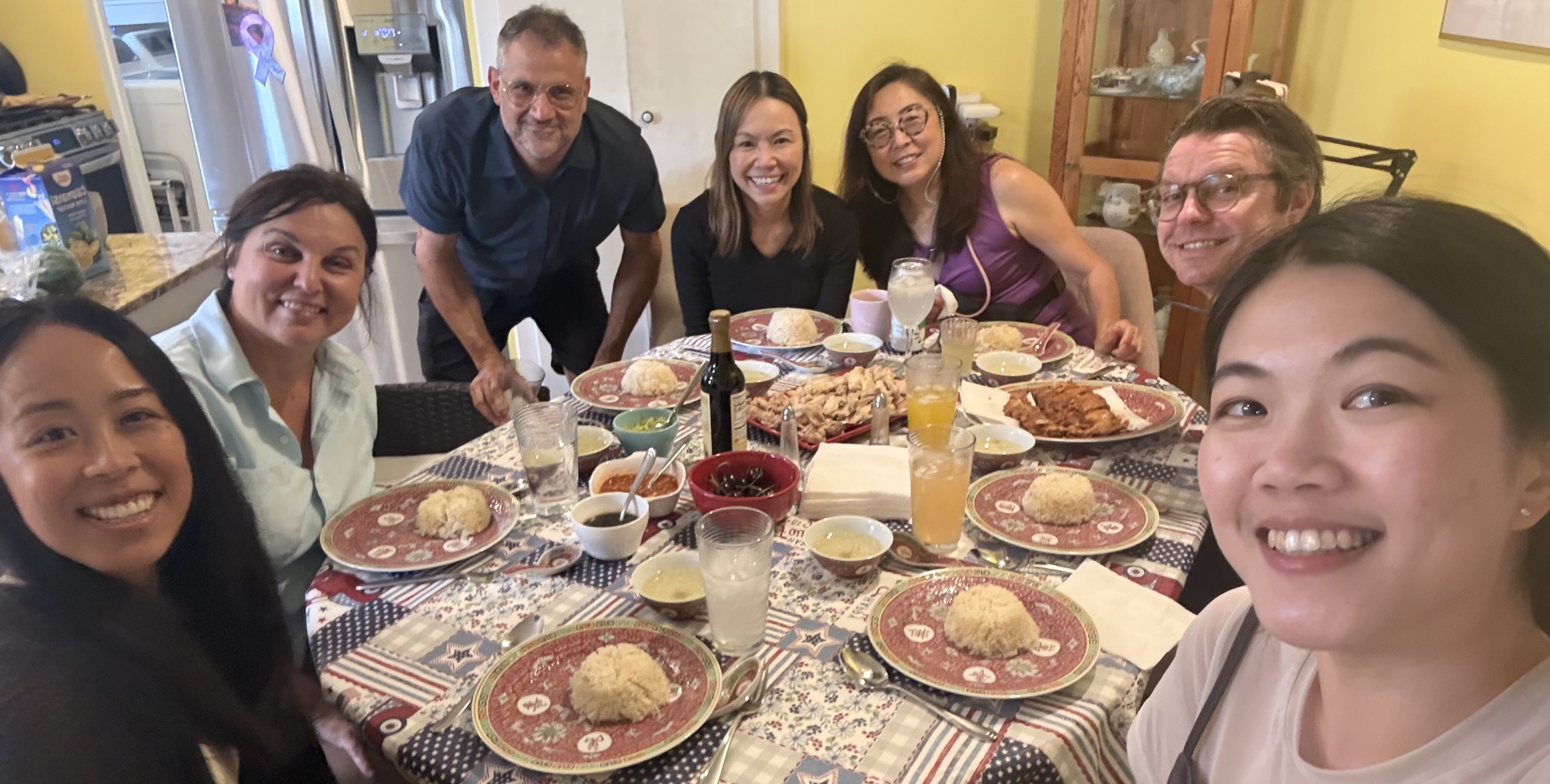 Friends sharing a meal and conversation around a table at a Kampong Collective gathering