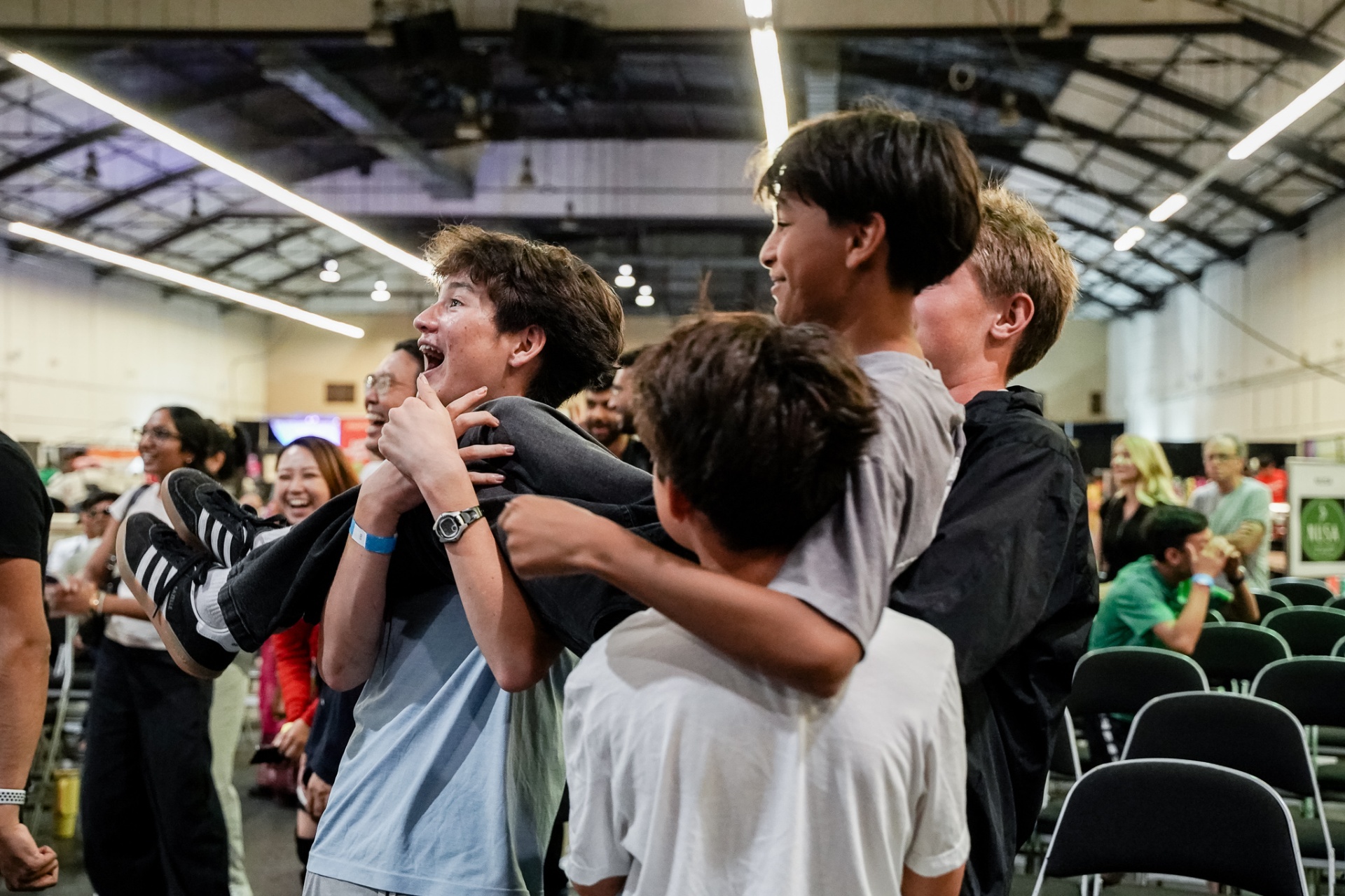 Kids laughing and lifting a friend at the festival