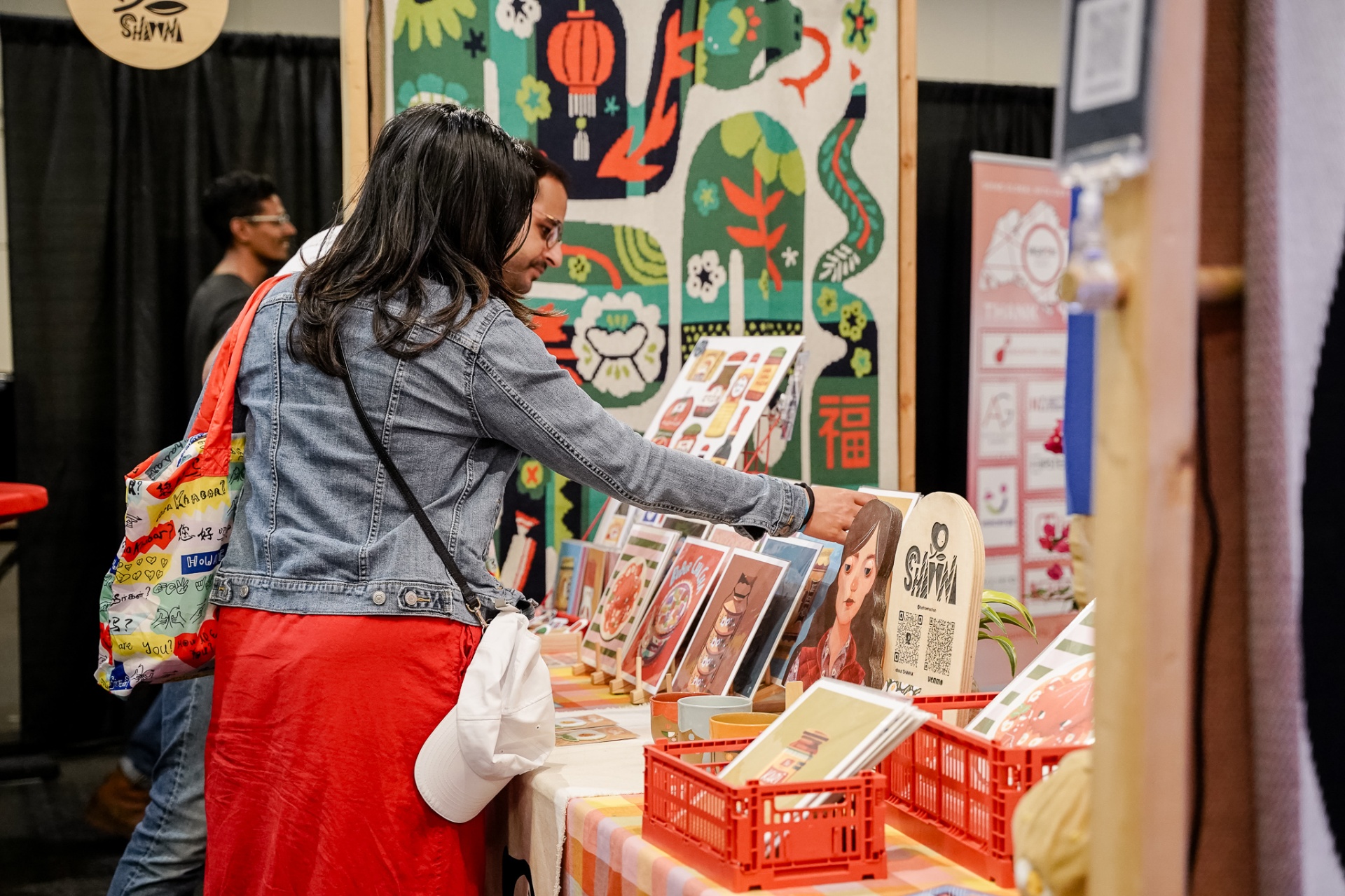 Visitor browsing illustrated art prints at vendor booth